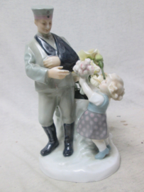 German statue made of china, nicely marked. Porseleinen beeld ( vaas) van een Duitse soldaat die gewond uit de Eerste Wereldoorlog terug komt en bloemen krijgt overhandigd. genummerd en gemerkt Zeldzaam stuk. TOP 19 cm..