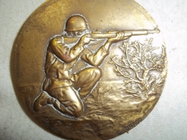 Military plaque shooting soldier, made by Drago.Franse penning met daarop een schietende soldaat, brons, gemaakt bij Drago.