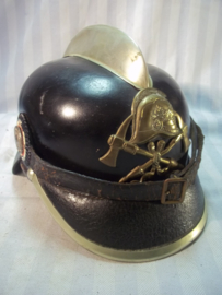 German firehelmet 1910- 1930, complete with 2 cocards. Duitse leren brandweerhelm, compleet met de 2 cocarden, binnenwerk, embleem, stormriem en zelfs de makerplaatjes.