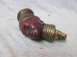 Old cork with the head of an African woman. Oude kurk met het hoofd van een Afrikaanse vrouw gemaakt van een soort papier mange. zeer decoratief en curieus.