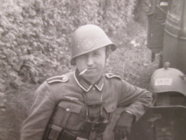 Photo German soldier wearing a Dutch helmet. Foto uit Russisch archief, Duitse soldaat met Nederlandse helm als oorlogs buit.