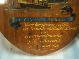 Hand geschilderde plaquette uitreiking Zilveren medaille Koninklijke marechaussee. getekend door J.Vet, zeer bekende kunstenaar van dit soort zaken.