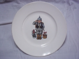 German humoristic plate a child dressed in a German uniform with spike helmet, made by VILLEROY and BOCH in Mettlach.Duits wandbord met militaire afbeelding kind in Duits uniform met pickelhaube, TOP staat.