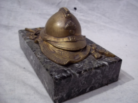 Press-papier, French miniature helmet on marble base. Franse miniatuurhelm met infanterie embleem in brons, liggend op vaandel gemonteerd op een marmeren voet, zeer decoratief.
