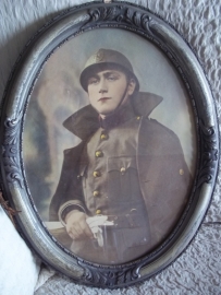 Photograph of a Belgium soldier in frame with helmet. Foto in lijst van een Belgische soldaat WO1 met helm ingekleurd.