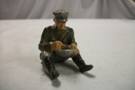German soldier eating. Duits speelgoed soldaatje eet uit messtin