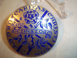 Zilveren draagspeld van de Katholieke Gezinszorg, met de zilver stempels erop.