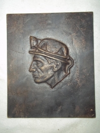 Bronze plaque of a miner wearing his typical helmet.Bronzen plaquette van een mijnwerker met zijn helm.