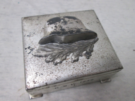 German box with steelhelmet, K.S.W. 1939. Duits doosje met daarop een metalen staalhelm en lauwertak. mooi jaren 30 doosje. afmeting is 8 bij 8 cm. zeer decoratief.