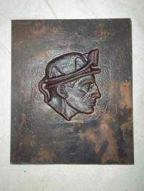 Bronze plaque of a miner wearing his typical helmet.Bronzen plaquette van een mijnwerker met zijn helm.