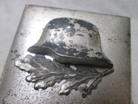German box with steelhelmet, K.S.W. 1939. Duits doosje met daarop een metalen staalhelm en lauwertak. mooi jaren 30 doosje. afmeting is 8 bij 8 cm. zeer decoratief.