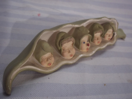 Curieus werkje van gips, stelt een boon voor met 5 erwten in de vorm van een gezichtje. de middelste heeft een lievenheersbeestje op zijn neus en is dus wakker.