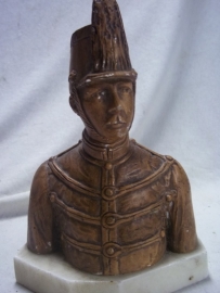 Statue of a Belgium soldier in ceremonial uniform.Buste van een belgische huzaar in dolman en met schako, beeldje is van gips met marmeren voet.