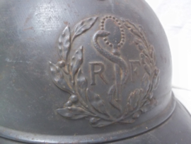 French helmet M-1915 of the Medical department. Franse helm casque adrianne model 1915 met embleem van de Militaire gezondheidszorg. in een zeer mooie staat met origineel binnenwerk, naam in helm gekrast, leer is gestempeld.