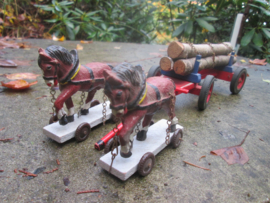 2 paarden met kar met boomstammen.
