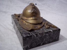 Press-papier, French miniature helmet on marble base. Franse miniatuurhelm met infanterie embleem in brons, liggend op vaandel gemonteerd op een marmeren voet, zeer decoratief.