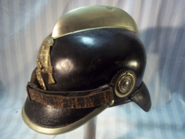 German firehelmet 1910- 1930, complete with 2 cocards. Duitse leren brandweerhelm, compleet met de 2 cocarden, binnenwerk, embleem, stormriem en zelfs de makerplaatjes.