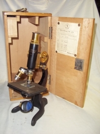 Microscope. Bronzen Microscoop in kist 1931, met enkele lensjes, met maker