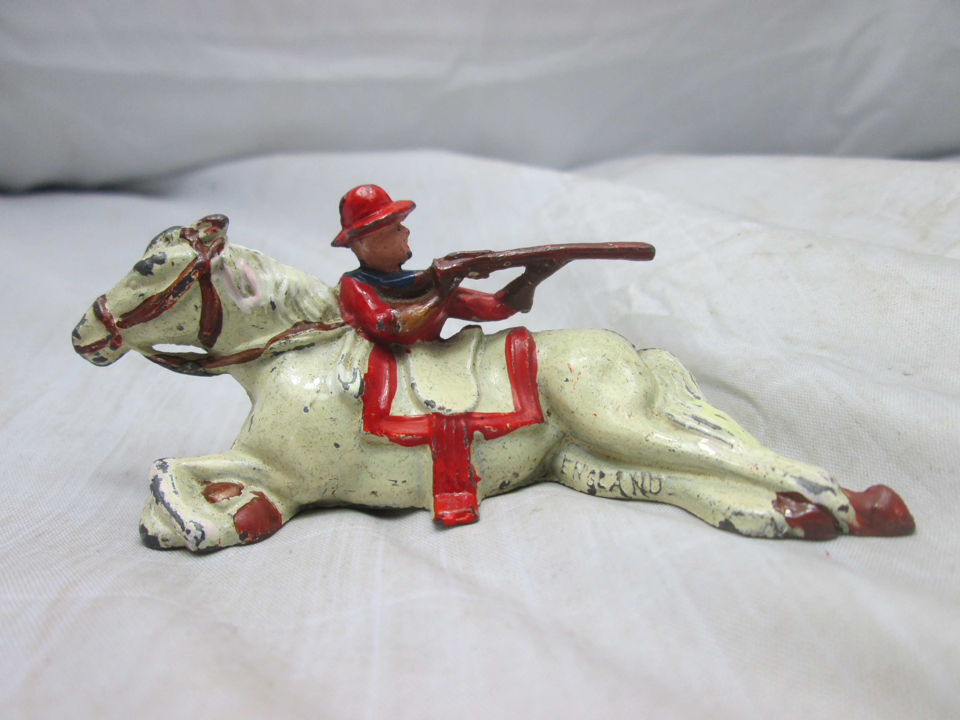 Tin toy, Britain made. tinnen cowboy die bescherming zoekt achter zijn paard leuk tafereel.