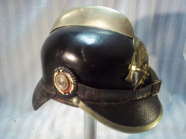 German firehelmet 1910- 1930, complete with 2 cocards. Duitse leren brandweerhelm, compleet met de 2 cocarden, binnenwerk, embleem, stormriem en zelfs de makerplaatjes.