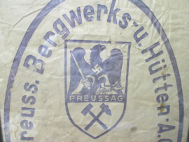 Piece of a paper bag. Stuk papier ingelijst, op de zak staat het embleem met hakenkruis van dit bedrijf. bijzonder, de rest van de zak is door muizen opgegeten.
