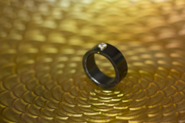 Zwarte ring met gouden zetting en diamant