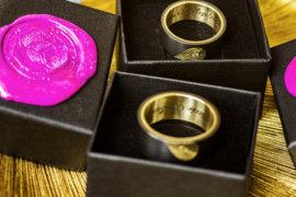 Zwarte trouwringen met gouden binnenzijde en gouden vingerafdruk