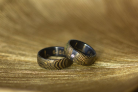 Zwarte ringen met goudkleurige vingerafdruk