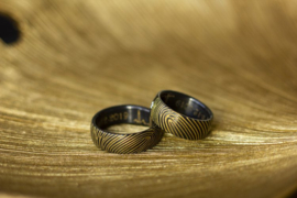 Zwarte ringen met goudkleurige vingerafdruk