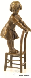 Bronzen beeld staand meisje op stoel