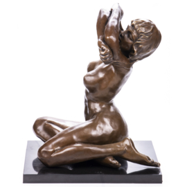 Naakte vrouw trekt BH uit bronsbeeld