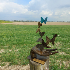 Bronzen hand met gekleurde vlinders