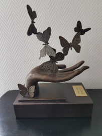 Bronzen hand met zes vlinders beeld