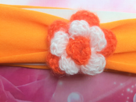 Oranje baby haarband met bloemetje.