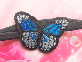 Smal zwart baby haarbandje met blauwe vlinder.