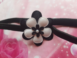 Smalle zwarte baby haarband met zwart/witte bloem.