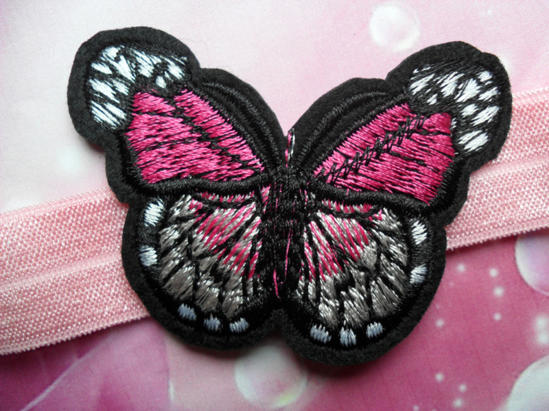 Smalle roze baby haarband met vlinder.