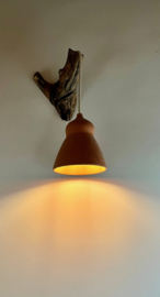 Terracotta lamp aan boomstronk