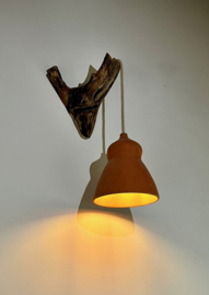 Terracotta lamp aan boomstronk