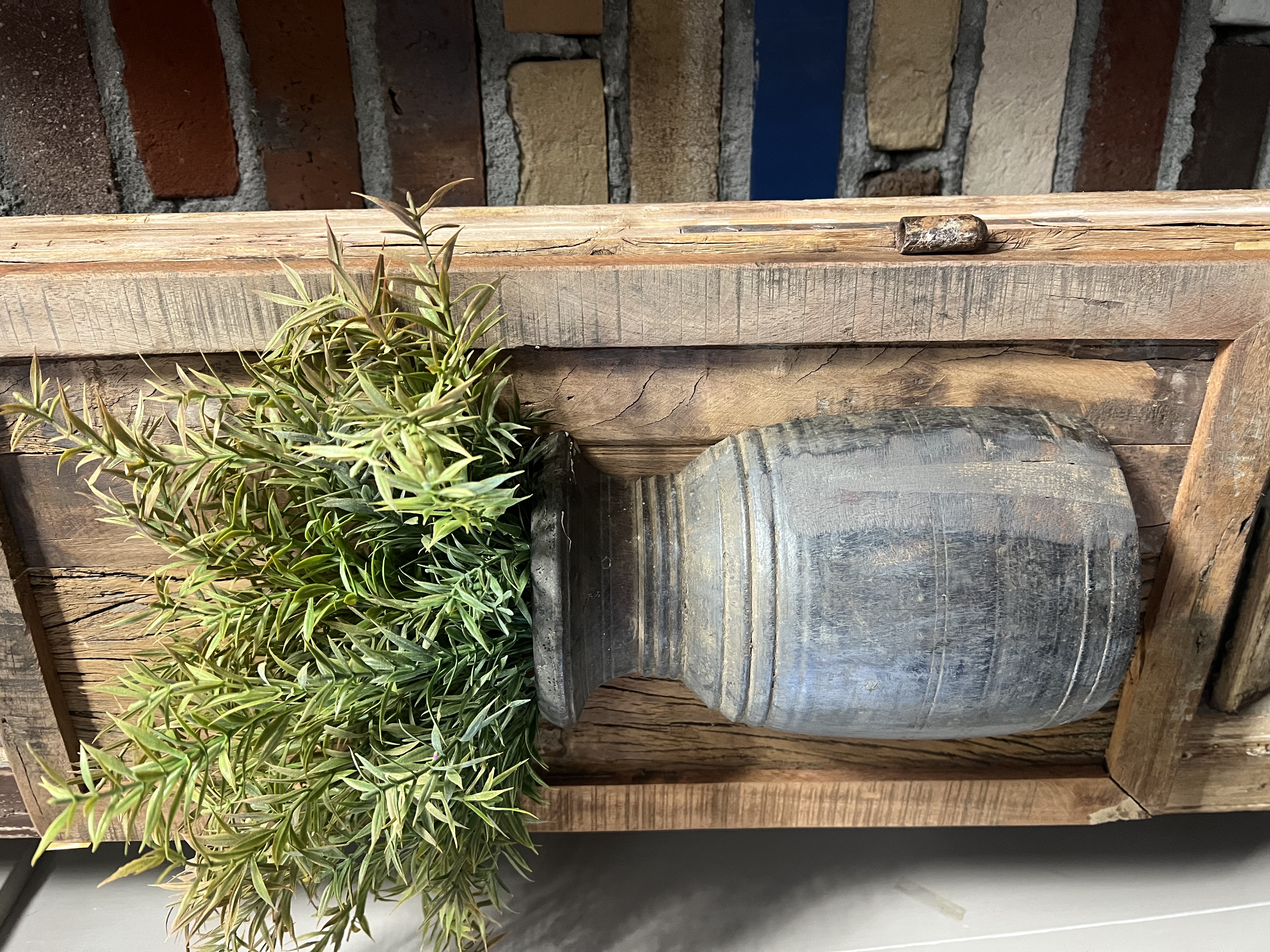 Wandbord (kader) met Nepalese kruik en een toef