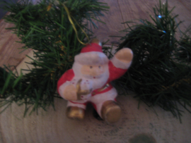 Zittende kerstman met pakje