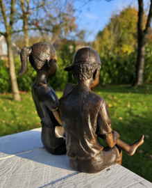 LEZEND MEISJE EN JONGEN MET PET