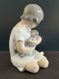 Royal Copenhagen porselein: nr 1938 Girl With Doll / Pige med Dukke ontwerp Adda Bonfils hoog 14 cm breed 11