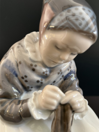 Royal Copenhagen porselein: nr. 1314 Amager Girl Knitting / Lille Strikkende Amargerpige ontwerp Lotte Bentler hoog 16 cm