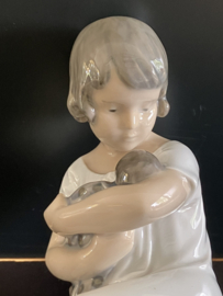 Royal Copenhagen porselein: nr 1938 Girl With Doll / Pige med Dukke ontwerp Adda Bonfils hoog 14 cm breed 11