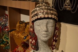 Hoed versierd met schelpjes en metalen plaatjes en met versierde nekflap.