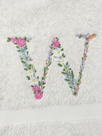 Cadeau geborduurd gastendoekje crème met bloemenletter en mini flesjes douche