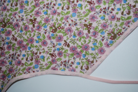 Een katoenen kapmanteltje met een klein bloemmotief in roze tinten.