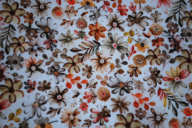 Een katoenen kapmanteltje met een dessin van allemaal bloemetjes in herfstkleuren.