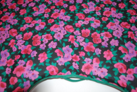 Een katoenen kapmanteltje van een crêpe stof met bloemen in roze, rood en paars. Nog 1 op voorraad.